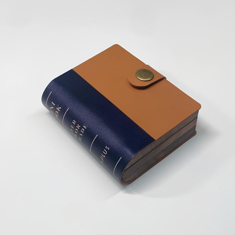 Closed walnut folio kit that looks like a navy and tan leather-bound book with a brass snap closure